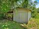 Exterior shot of wooden shed with double doors and adjacent storage area, surrounded by greenery at 3441 Sherertz Rd, Lakeland, FL 33810