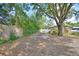 Backyard featuring seating area surrounded by mature trees, offering a private and natural setting for relaxation and gatherings at 346 Tanager Ct, Lakeland, FL 33803