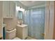 Bright bathroom featuring a shower with a patterned curtain and white single sink vanity at 346 Tanager Ct, Lakeland, FL 33803