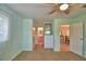 Sunlit bedroom with carpet, a ceiling fan, and built-in storage cabinets, leading to an attached bathroom at 346 Tanager Ct, Lakeland, FL 33803