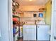 Functional laundry room with washer, dryer, and shelving for storage at 346 Tanager Ct, Lakeland, FL 33803
