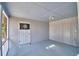 Grey sunroom with blue ceiling, painted brick walls, and a dartboard by the screened-in porch at 346 Tanager Ct, Lakeland, FL 33803