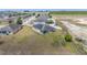 Aerial view of the home showcasing its backyard, solar panels, and neighboring houses and landscape at 3560 Spring Creek Rd, Dundee, FL 33838