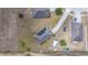 Aerial view showcasing solar panels, shed, and long driveway surrounded by well-maintained lawns at 3560 Spring Creek Rd, Dundee, FL 33838
