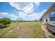 Expansive backyard featuring lush green grass, a sapling tree, and space for outdoor activities at 3560 Spring Creek Rd, Dundee, FL 33838