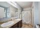 Bright bathroom features a double sink vanity, framed mirror, and patterned shower curtain at 3560 Spring Creek Rd, Dundee, FL 33838