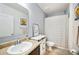 Bright bathroom features a single sink vanity, mirror, and a shower with a patterned curtain at 3560 Spring Creek Rd, Dundee, FL 33838