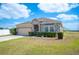 Inviting home with stone details, a two-car garage, and a tidy lawn with neatly trimmed hedges enhancing curb appeal at 3560 Spring Creek Rd, Dundee, FL 33838