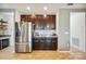 A kitchen with stainless steel refrigerator, dark wood cabinets, and granite countertops provides modern appeal at 3560 Spring Creek Rd, Dundee, FL 33838