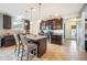 Modern kitchen featuring dark wood cabinetry, granite countertops, and a center island with barstool seating at 3560 Spring Creek Rd, Dundee, FL 33838