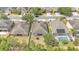This aerial view highlights the home's grassy backyard, mature tree coverage, and fenced-in yard at 3592 Prescott Loop, Lakeland, FL 33810