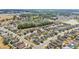 This aerial shot shows a residential neighborhood with manicured lawns and houses with tree coverage and a large pond at 3592 Prescott Loop, Lakeland, FL 33810