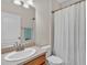 Bathroom features a vanity, mirror and shower with white shower curtain at 3592 Prescott Loop, Lakeland, FL 33810