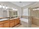 Bright bathroom features double sinks, granite counters, soaking tub, and glass shower enclosure at 3592 Prescott Loop, Lakeland, FL 33810