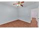 Comfortable bedroom with lovely wood floors, a ceiling fan, and an open doorway at 3592 Prescott Loop, Lakeland, FL 33810