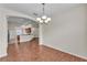 Open dining room with hardwood floors, modern chandelier and entrance to kitchen at 3592 Prescott Loop, Lakeland, FL 33810