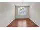 Simple dining area with hardwood floors, chandelier, and natural light from a large window at 3592 Prescott Loop, Lakeland, FL 33810