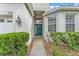 Inviting front entrance with a green door, decorative sidelight window, and lush shrubbery at 3592 Prescott Loop, Lakeland, FL 33810