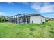 Expansive backyard view showing the screened-in pool area and manicured lawn at 3664 Frentress Dr, Lakeland, FL 33812