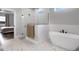 Bright bathroom featuring marble floors, a modern tub, and a glass-enclosed shower at 3664 Frentress Dr, Lakeland, FL 33812