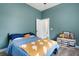 Blue bedroom with yellow comforter, closet, and view into the ensuite bath at 3664 Frentress Dr, Lakeland, FL 33812