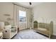Bedroom with a crib, chair, and view of the neighborhood through the window at 3664 Frentress Dr, Lakeland, FL 33812