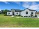 Beautiful one-story home with white exterior, dark roof, manicured lawn and elegant stone accents at 3664 Frentress Dr, Lakeland, FL 33812