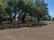 Spacious backyard with mature trees providing ample shade on a sunny day at 3705 Garland St, Mulberry, FL 33860