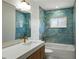 Well-lit bathroom featuring a marble countertop, a wooden vanity and an elegant tiled shower and tub at 3705 Garland St, Mulberry, FL 33860
