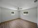 Bright and airy bedroom featuring neutral walls, a ceiling fan, large windows, and durable LVP flooring at 3705 Garland St, Mulberry, FL 33860