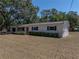 Charming single-story home with fresh exterior paint, shutters, a new roof and mature trees at 3705 Garland St, Mulberry, FL 33860