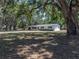 Exterior view of the home with blue shutters and garage door, set on a spacious lot with mature trees at 3705 Garland St, Mulberry, FL 33860