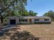 Inviting exterior showcasing the home's neutral siding, blue shutters, and well-manicured landscaping at 3705 Garland St, Mulberry, FL 33860