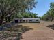 Charming single-story home with a well-maintained front yard and mature trees providing shade at 3705 Garland St, Mulberry, FL 33860