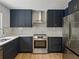 Updated kitchen features stainless steel appliances, solid surface countertops, and blue cabinets at 3705 Garland St, Mulberry, FL 33860