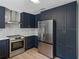 Updated kitchen features stainless steel appliances, solid surface countertops, and blue cabinets at 3705 Garland St, Mulberry, FL 33860