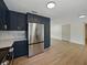 Modern kitchen features stainless steel appliances, dark blue cabinets, and an open floor plan at 3705 Garland St, Mulberry, FL 33860