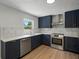 Updated kitchen with stainless steel appliances, solid surface countertops, and blue cabinets at 3705 Garland St, Mulberry, FL 33860