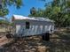 Storage shed featuring a new metal roof, situated in the yard with mature trees at 3705 Garland St, Mulberry, FL 33860