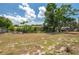 The open backyard features sparse lawn with mature trees and views to nearby houses at 400 6Th Ne St, Fort Meade, FL 33841