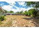 Large, open backyard featuring sparse lawn, mature trees, and wooded fence line at 400 6Th Ne St, Fort Meade, FL 33841
