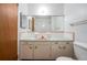 Dated bathroom featuring pink cabinets, a large mirror, and standard sink, toilet, and door at 400 6Th Ne St, Fort Meade, FL 33841