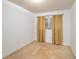 A bedroom with neutral carpet, white walls, and a window covered with gold colored curtains at 400 6Th Ne St, Fort Meade, FL 33841