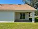 Covered back patio with sliding glass doors overlooking the grass and landscaping at 4058 Oak Loop # 99, Mulberry, FL 33860
