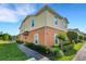 Two-story townhome showcases manicured landscaping, a symmetrical walkway, and a two-tone paint scheme at 4078 Winding Vine Dr, Lakeland, FL 33812