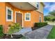 Inviting front entry with neatly trimmed bushes and flowers surrounding the concrete walkway at 4078 Winding Vine Dr, Lakeland, FL 33812