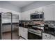 Modern kitchen features stainless steel appliances, white cabinets, and elegant black countertops at 4078 Winding Vine Dr, Lakeland, FL 33812