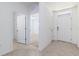 Bright hallway with neutral tile flooring leads to rooms, offering easy access to bedrooms and bathrooms at 4203 San Rocco Way, Winter Haven, FL 33884