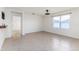 Neutral-toned living room with tile flooring, a ceiling fan, and ample natural light from a window at 4203 San Rocco Way, Winter Haven, FL 33884