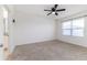 Cozy main bedroom features neutral carpet, a ceiling fan, and a window for natural light and adjoining bath at 4203 San Rocco Way, Winter Haven, FL 33884